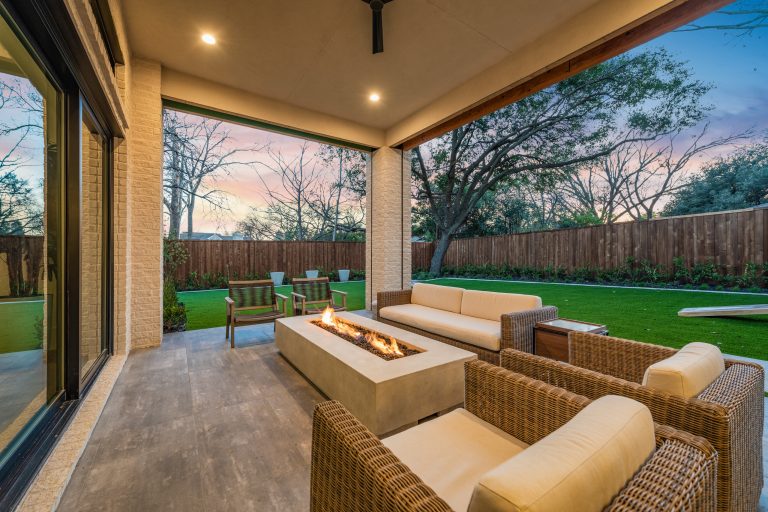 Example of a large minimalist backyard concrete paver patio design in Dallas with a fire pit and a roof extension