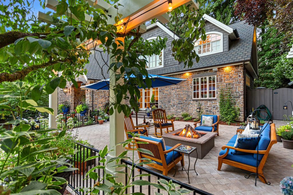 Inspiration for a large traditional drought-tolerant and full sun front yard concrete paver and metal fence landscaping in Portland with a fire pit.