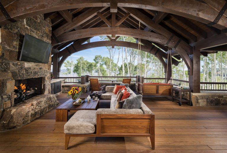 Large mountain style backyard deck photo in Salt Lake City with a fire pit and a roof extension