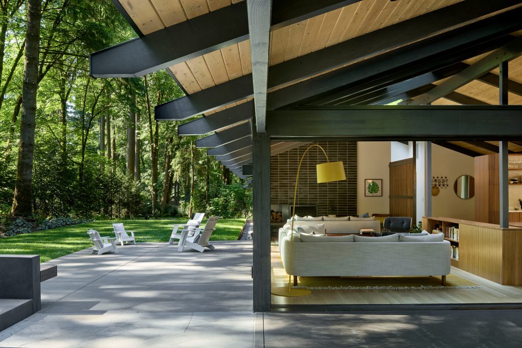 Inspiration for a large mid-century modern side yard concrete patio remodel in Portland with a fire pit and a roof extension