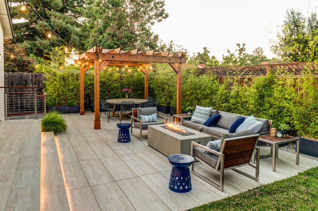 Example of a transitional tile patio design in San Francisco with a fire pit and a pergola