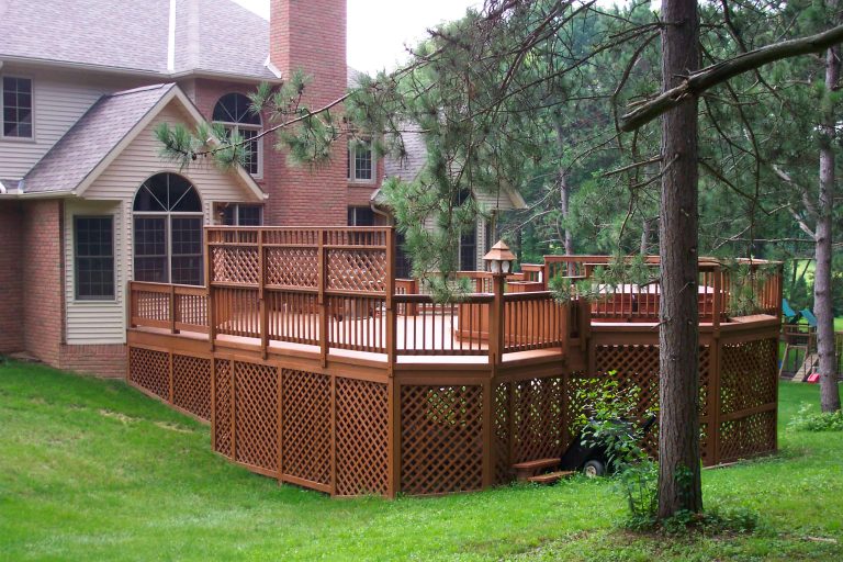 A beautiful deck with a hot tub and privacy fence.
