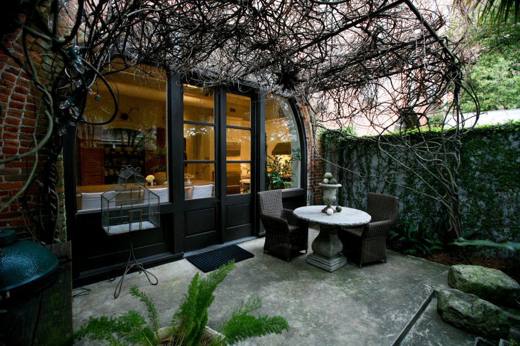 A canopied courtyard right off the kitchen, where one of several original arched brick delivery openings was infilled with glass and French doors, affords year-round alfresco dining opportunities.