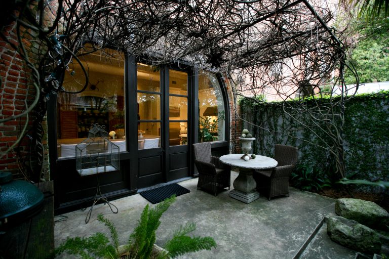 A canopied courtyard right off the kitchen, where one of several original arched brick delivery openings was infilled with glass and French doors, affords year-round alfresco dining opportunities.