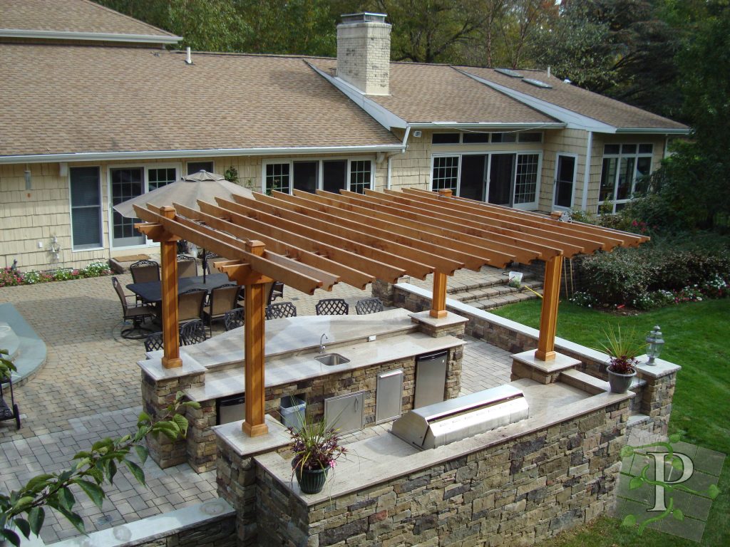 A complete outdoor kitchen and bar with pergola for shade over a paver patio. See more of our work here: https://www.platinumsdgroup.com/