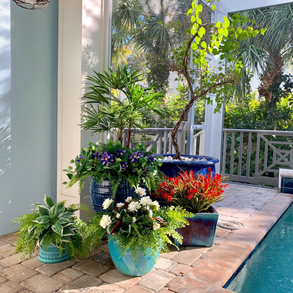 A cozy, intimate pool lanai becomes that much more enjoyable with bright, colorful plantings of aritficial outdoor plants that never need watering.