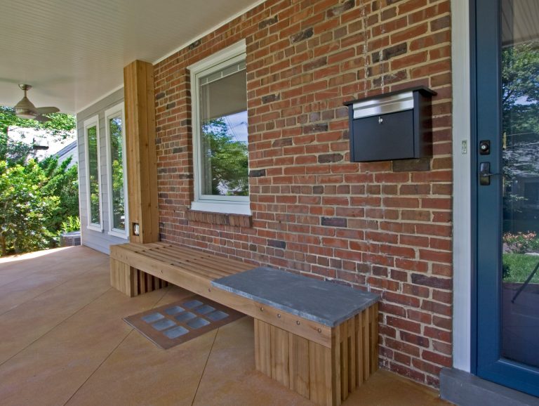 A custom bench provides a place to read the mail and hides the gas and electric meters. A custom glass and concrete window well cover brings light into the basement. by Braitman Design Studio | Outdoor Photos | Porch | Landscaping | Landscape Design | Outdoor Living Space | Porch Design Ideas | Outdoor Living Space Ideas | Backyard Design