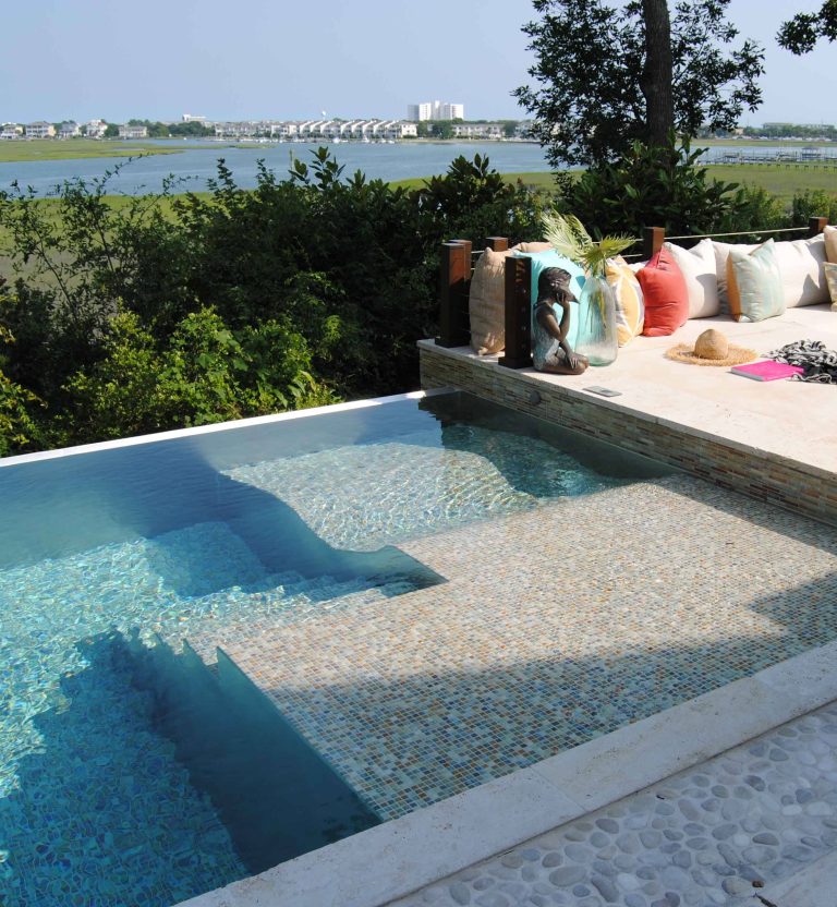 A custom designed stainless steel pool with artistic tile and an infinity edge overlooking the coastal waterfront location.