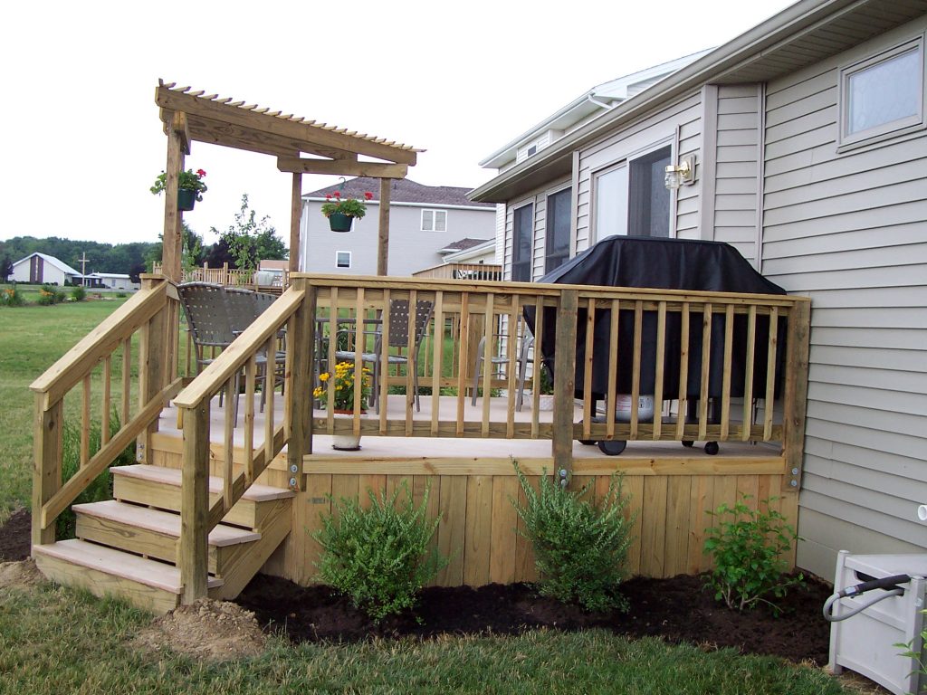 A deck with a trellis (pergola) and solid board skirting.
