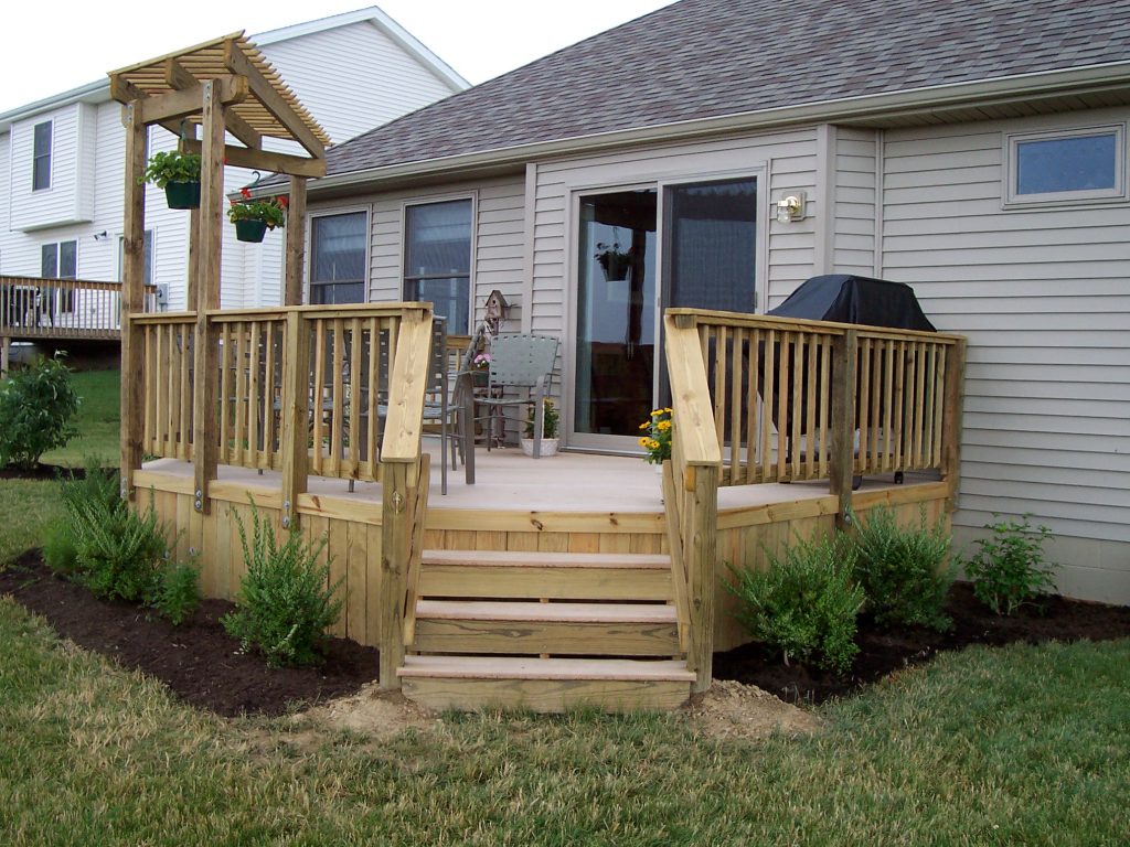 A deck with a trellis (perogla) and solid board skirting.