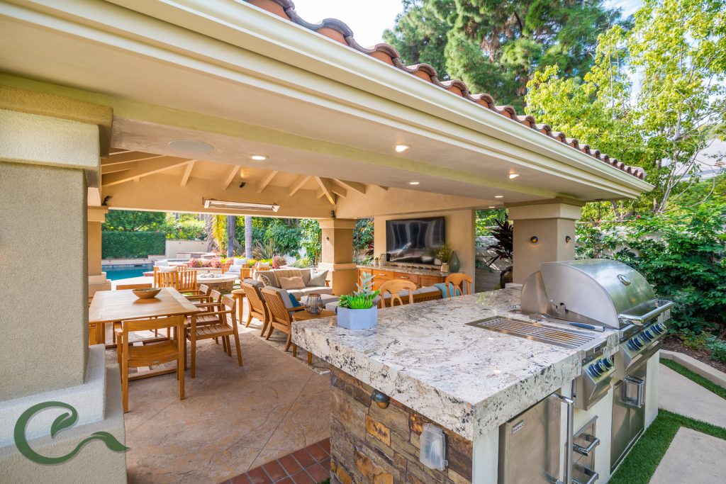 A detached solid roof patio cover helped to complete this yard by creating a comfortable, relaxing, and protected space for entertaining, cooking, and dining.