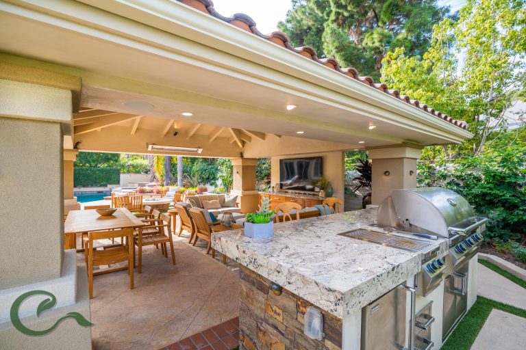 A detached solid roof patio cover helped to complete this yard by creating a comfortable, relaxing, and protected space for entertaining, cooking, and dining.