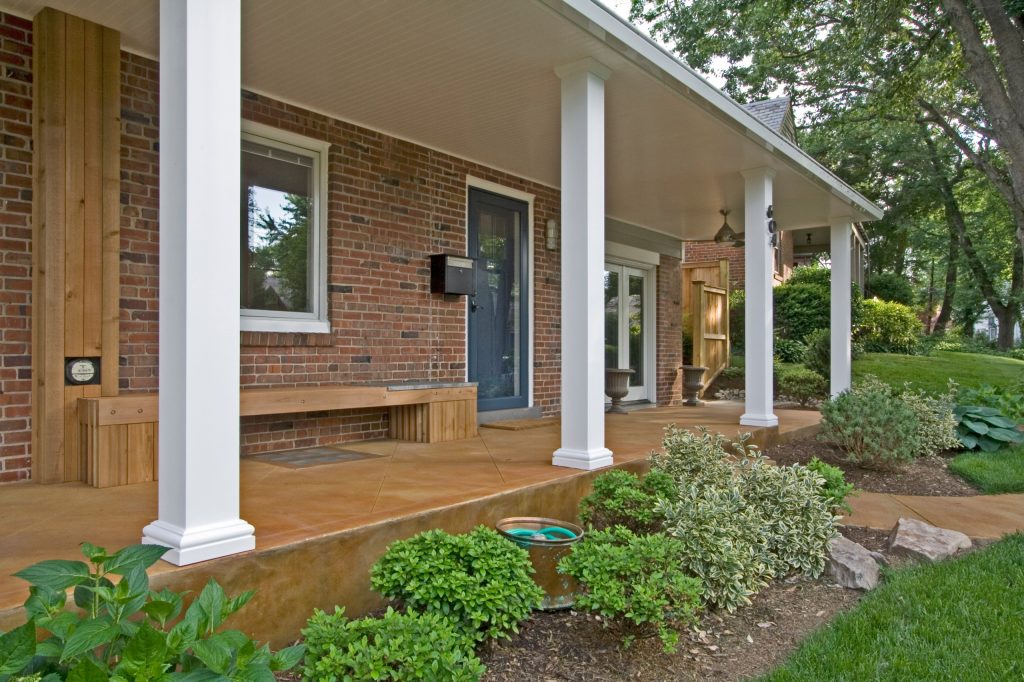 A full-length front porch extends the house and greets the neighborhood. The square columns create a sense of rhythm welcoming visitors. Trendy porch photo in DC Metro by Braitman Design Studio | Outdoor Photos | Porch | Landscaping | Landscape Design | Outdoor Living Space | Porch Design Ideas | Outdoor Living Space Ideas | Backyard Design