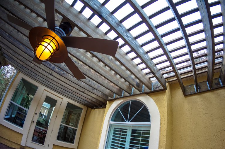A great patio is a continuation of your home. This outdoor living space has you covered with an expansive custom pergola design. To help with the Florida heat, we added a chic fan to help cool down.