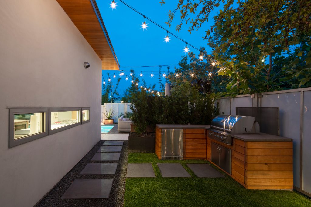 A grill area is sequestered to the side of the pool.