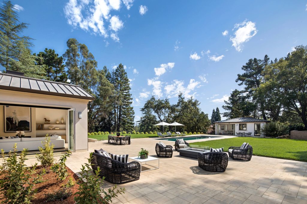 A large pool and patio integrate the home with back yard and pool house. Folding doors open on two sides for indoor/outdoor living. Bernard Andre Photography