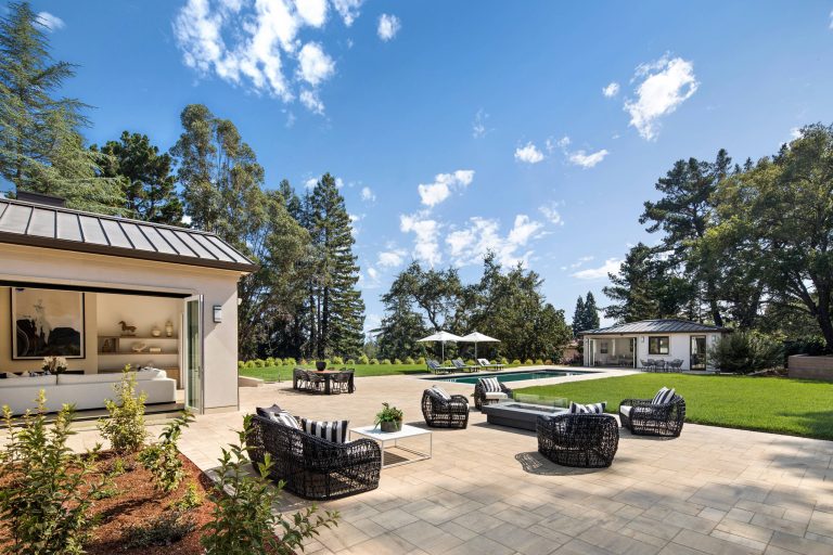 A large pool and patio integrate the home with back yard and pool house. Folding doors open on two sides for indoor/outdoor living. Bernard Andre Photography