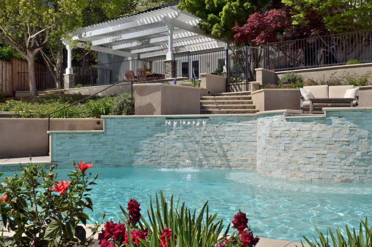 A raised masonry wall is faced with beautiful natural ledge stone adding dimension and visual interest to this beautiful swimming pool. Tom Minczeski photographer
