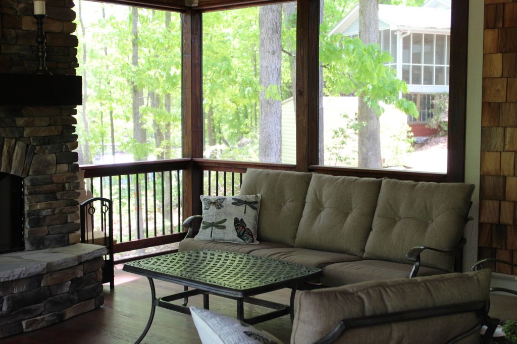 A stacked stone fireplace on the screened-in porch adds charm and warmth.
