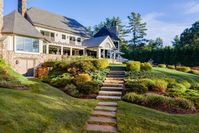 A stunning home with beautiful landscaping. The veneer is New England Fieldstone. The steps, treads and pavers are bluestone.