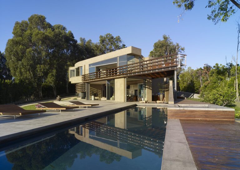 A view of the ocean-facing side of the house over the pool.