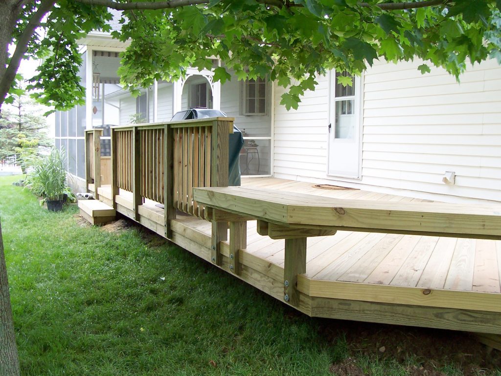 A wood deck with wood rails and a wood bench.