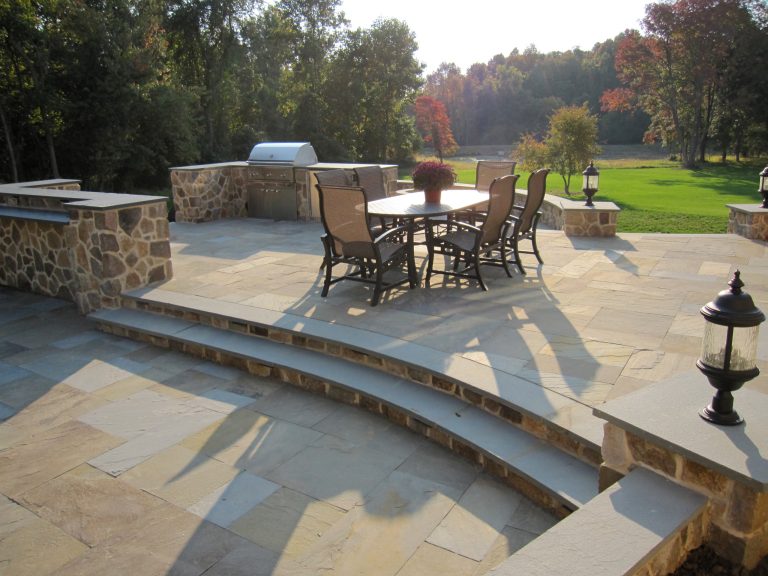An outdoor living space with grill and ample counter space for gathering