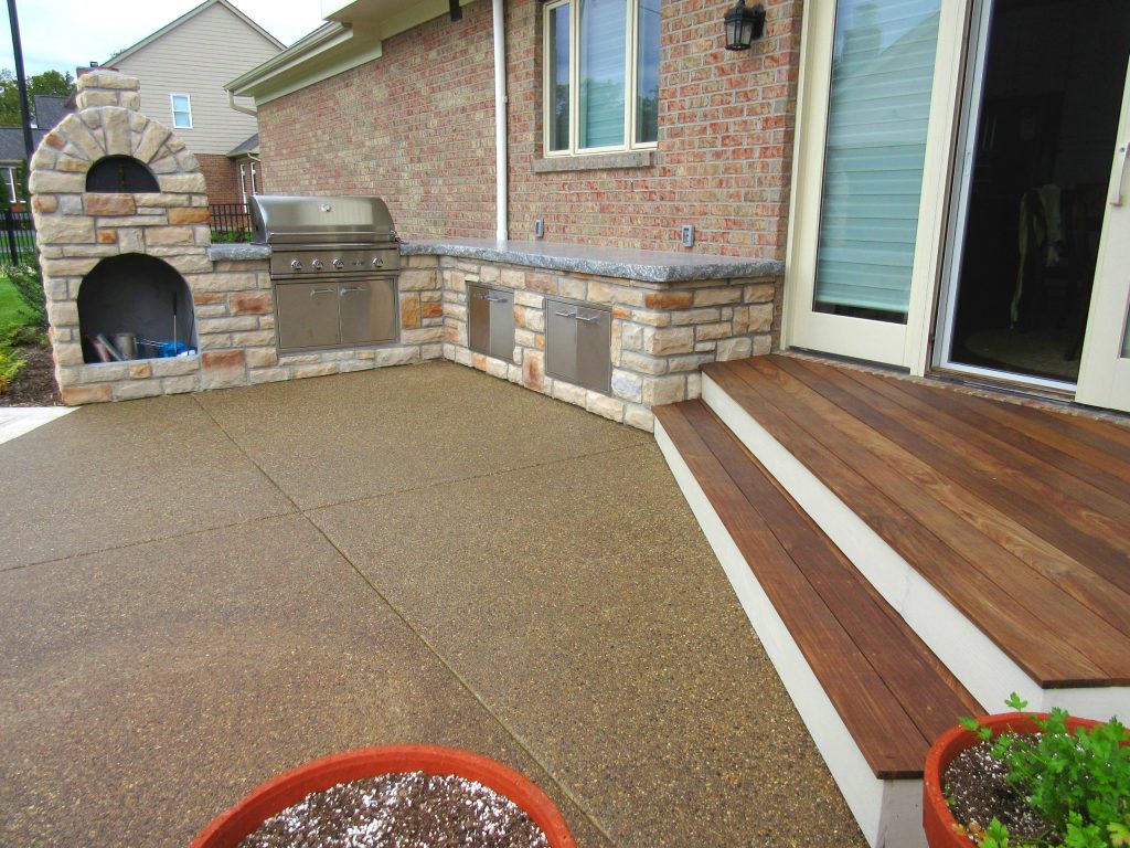 Angled deck leading out to a grilling patio with pizza oven