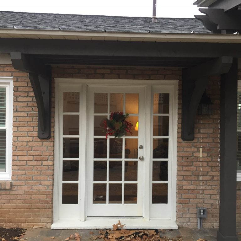 Arbor added over this back door. Paver patio surface for the patio space on this backyard makeover.