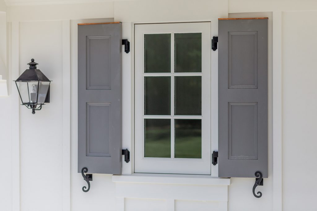 Authentic shutter detailing with active hardware and hinges. Copper flashing cap above the paneled shutters highlighting a small divided lite window. A carriage light completes the composition. by Young & Borlik Architects, inc. | Outdoor Photos | Porch | Landscaping | Landscape Design | Outdoor Living Space | Porch Design Ideas | Outdoor Living Space Ideas | Backyard Design