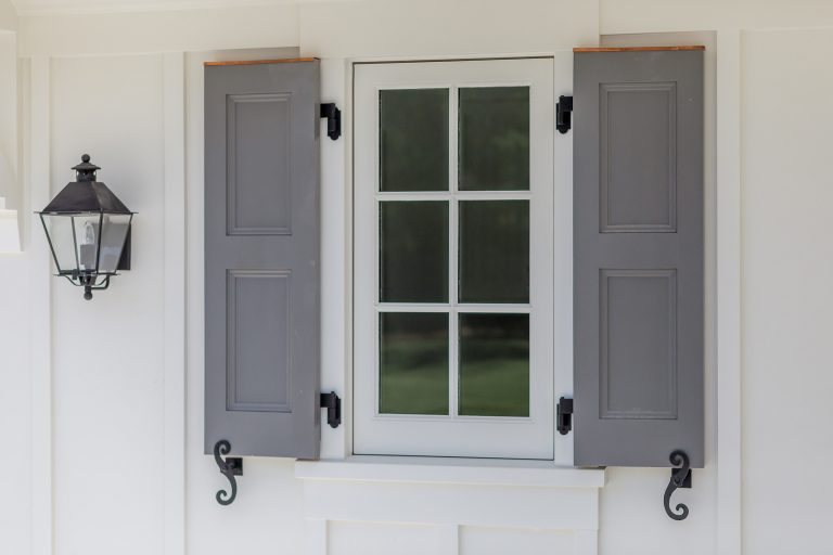 Authentic shutter detailing with active hardware and hinges. Copper flashing cap above the paneled shutters highlighting a small divided lite window. A carriage light completes the composition. by Young & Borlik Architects, inc. | Outdoor Photos | Porch | Landscaping | Landscape Design | Outdoor Living Space | Porch Design Ideas | Outdoor Living Space Ideas | Backyard Design