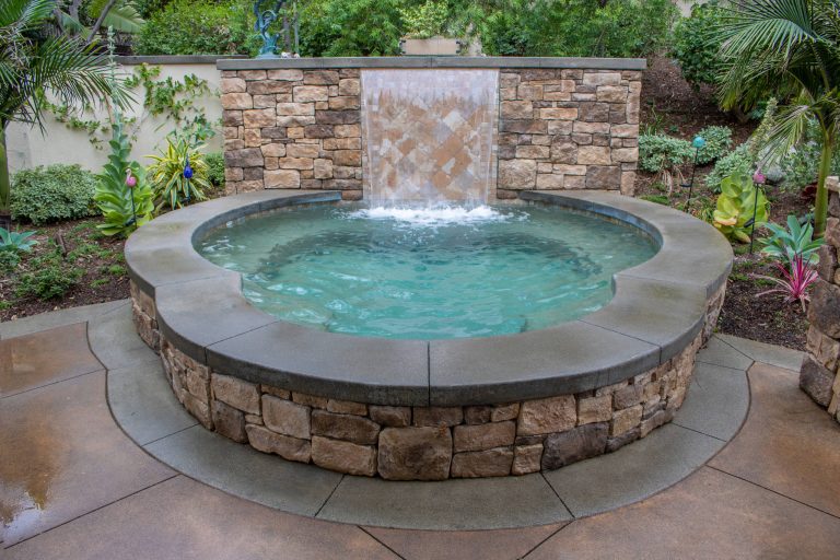 Backyard Spa with water feature. Stone Veneer with Concrete caps.