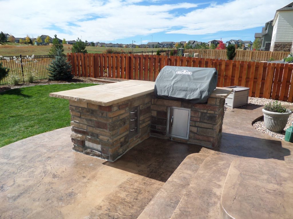 Backyard built-in flagstone barbecue with cooking and eating area.