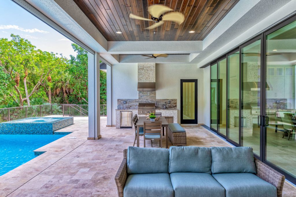 Backyard outdoor kitchen deck photo in Miami with a roof extension