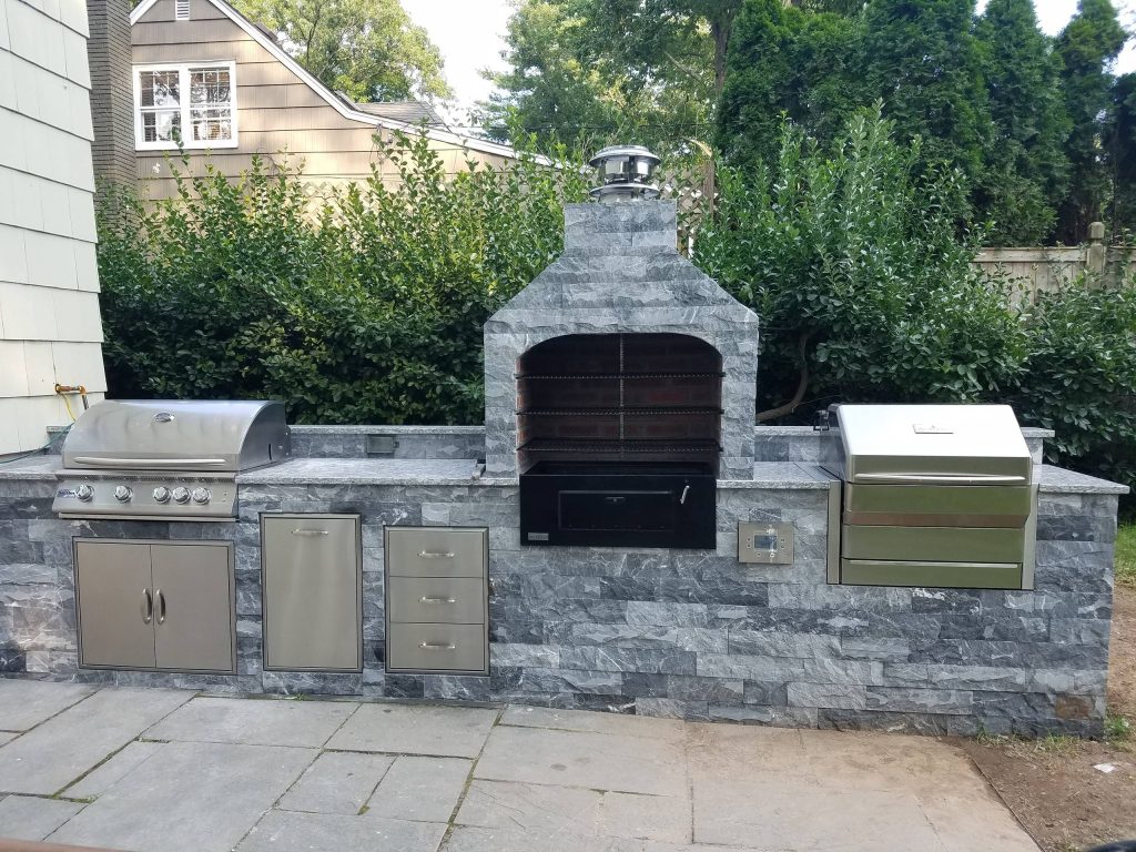 Backyard patio kitchen photo in New York