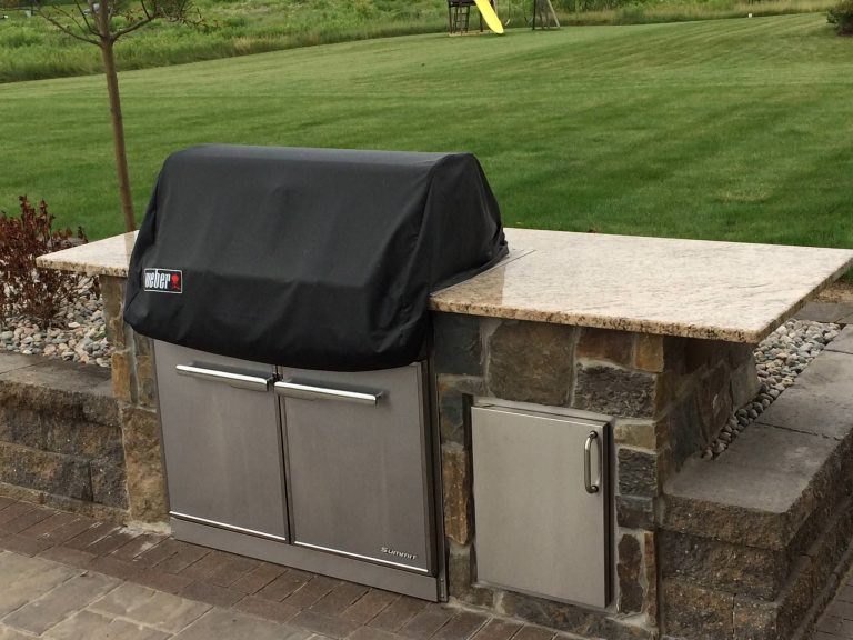 Basic outdoor kitchen complete with built-in grill, stainless steel storage and granite countertop.