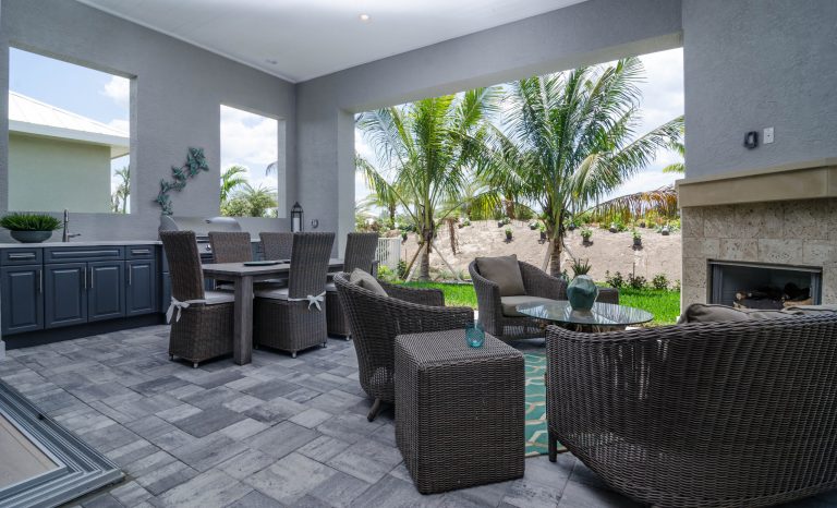 Beach style backyard concrete paver patio kitchen photo in Miami with a roof extension by Marvin Development Corporation | Outdoor Photos | Porch | Landscaping | Landscape Design | Outdoor Living Space | Porch Design Ideas | Outdoor Living Space Ideas | Backyard Design