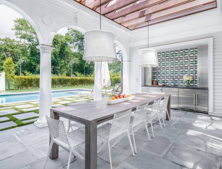 Beach style backyard patio kitchen photo in New York with a pergola