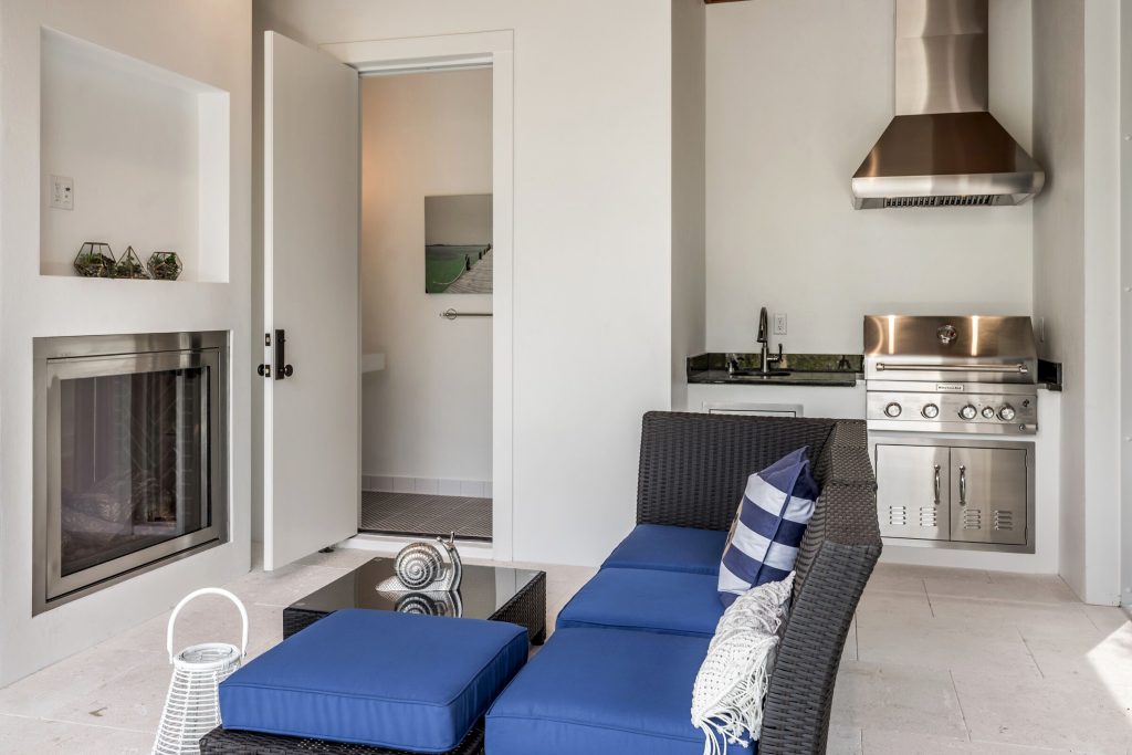 Beach style backyard stone patio kitchen photo in Miami with a roof extension