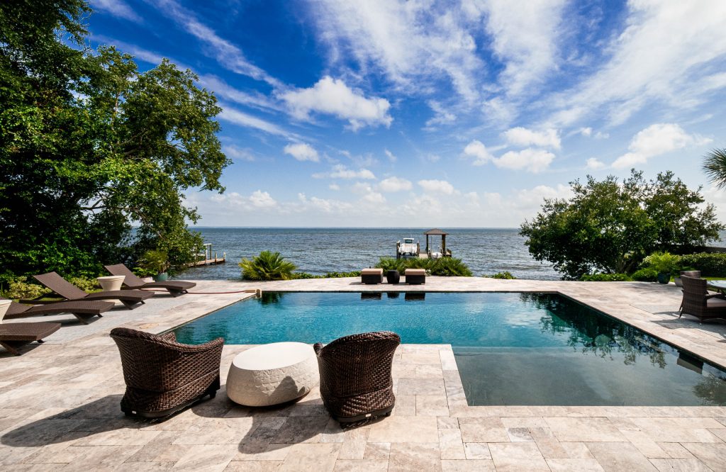 Beach style backyard tile and l-shaped pool photo in Miami