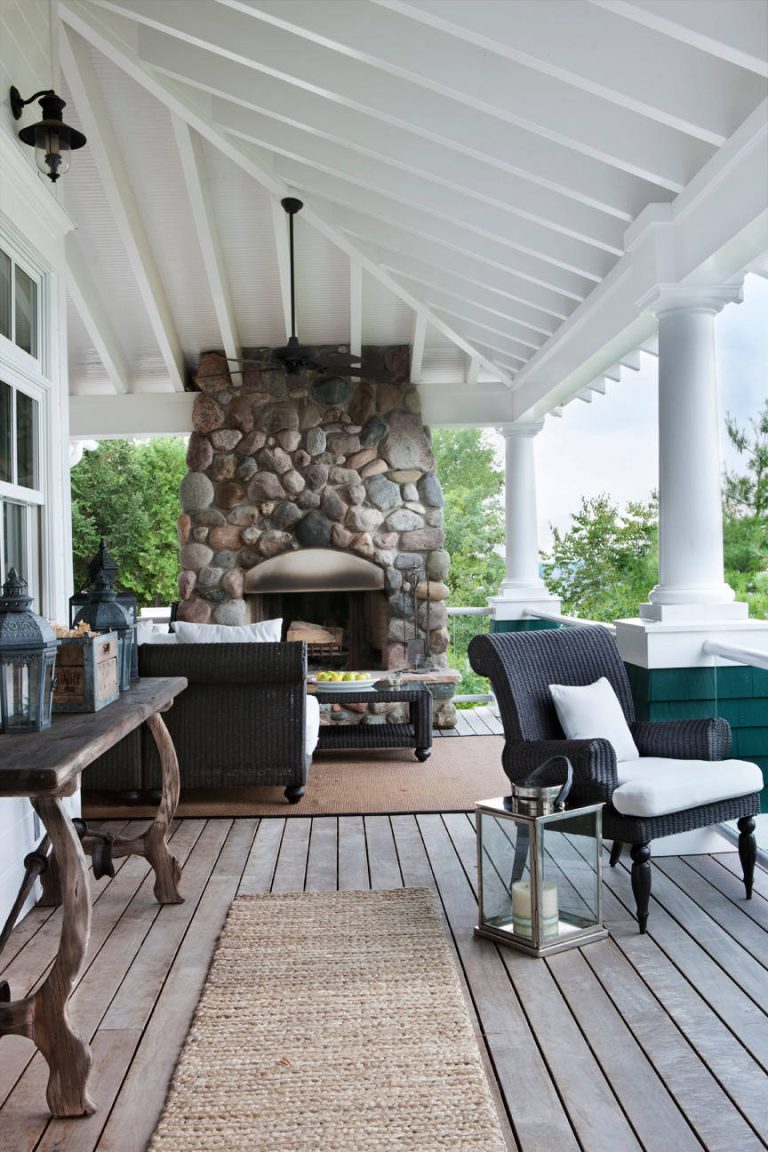 Beach style front porch idea in Other with a fire pit, decking and a roof extension by Cottage Company of Harbor Springs | Outdoor Photos | Porch | Landscaping | Landscape Design | Outdoor Living Space | Porch Design Ideas | Outdoor Living Space Ideas | Backyard Design