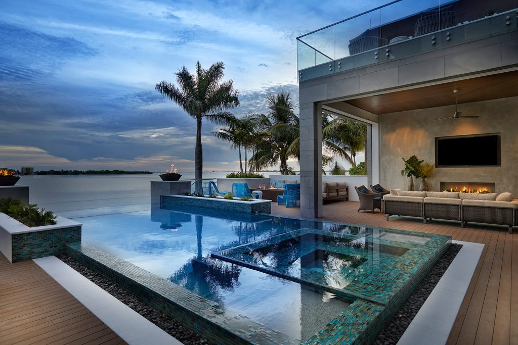 Beach style rectangular infinity hot tub photo in Miami with decking