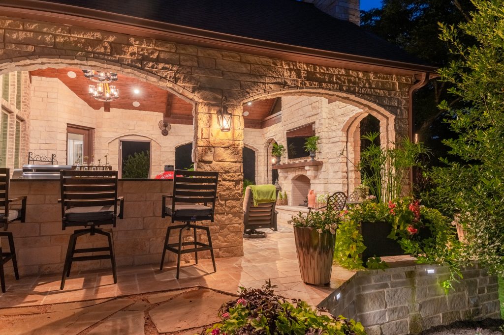 Beautiful lighting throughout the entire project!

Photography credit: Snap Point MediaMid-sized transitional backyard stone patio kitchen photo in Dallas with a roof extension by TCP Custom Outdoor Living | Outdoor Kitchens | Backyard Design | Outdoor Living Spaces | Landscape Design