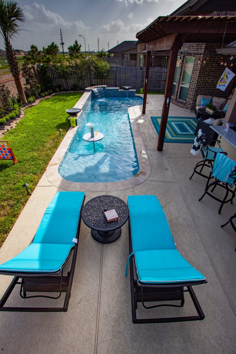 Beautiful resort-like cocktail pool with a cocktail table. Includes three water features and glass tile. Custom outdoor kitchen with a Big Green Egg and a cozy covered seating area.
