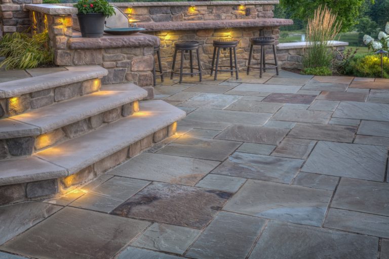Built in grille and bar area are adjacent to tall masonry wall. Their location promotes easy circulation from house, patio and fireplace areas. Lighting extends project use into the night. by Suncrest Gardens | Outdoor Kitchens | Backyard Design | Outdoor Living Spaces | Landscape Design