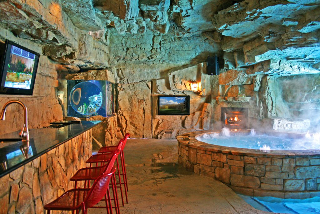 This luxurious man cave features 12 ft. high ceilings, a spa, hidden doors, a bathroom, A/C, floor heat and more. Spa & pool by Anthony Sullivan, MD.