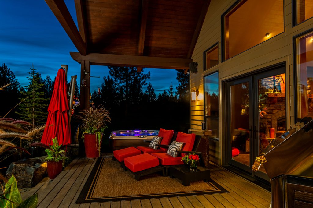 Carrying the rustic, traditional style of the home outdoors, this porch provides multiple areas of relaxation, from the hot tub to the reclining chairs. by Alderwood Landscape Architecture and Construction | Outdoor Photos | Porch | Landscaping | Landscape Design | Outdoor Living Space | Porch Design Ideas | Outdoor Living Space Ideas | Backyard Design