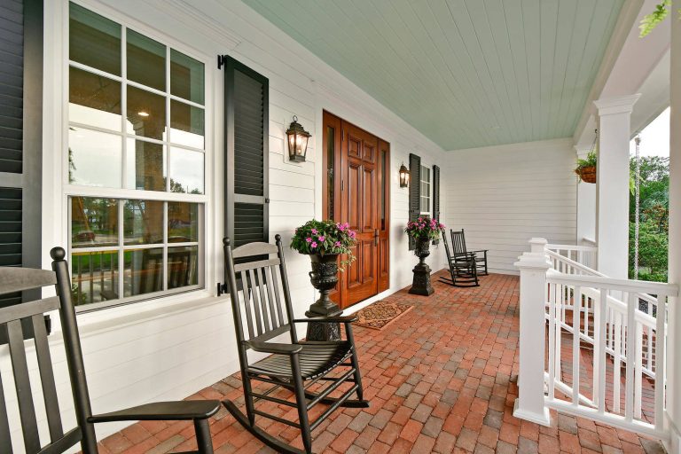Classic brick front porch idea in Tampa with a roof extension by Bruce Williams Homes | Outdoor Photos | Porch | Landscaping | Landscape Design | Outdoor Living Space | Porch Design Ideas | Outdoor Living Space Ideas | Backyard Design