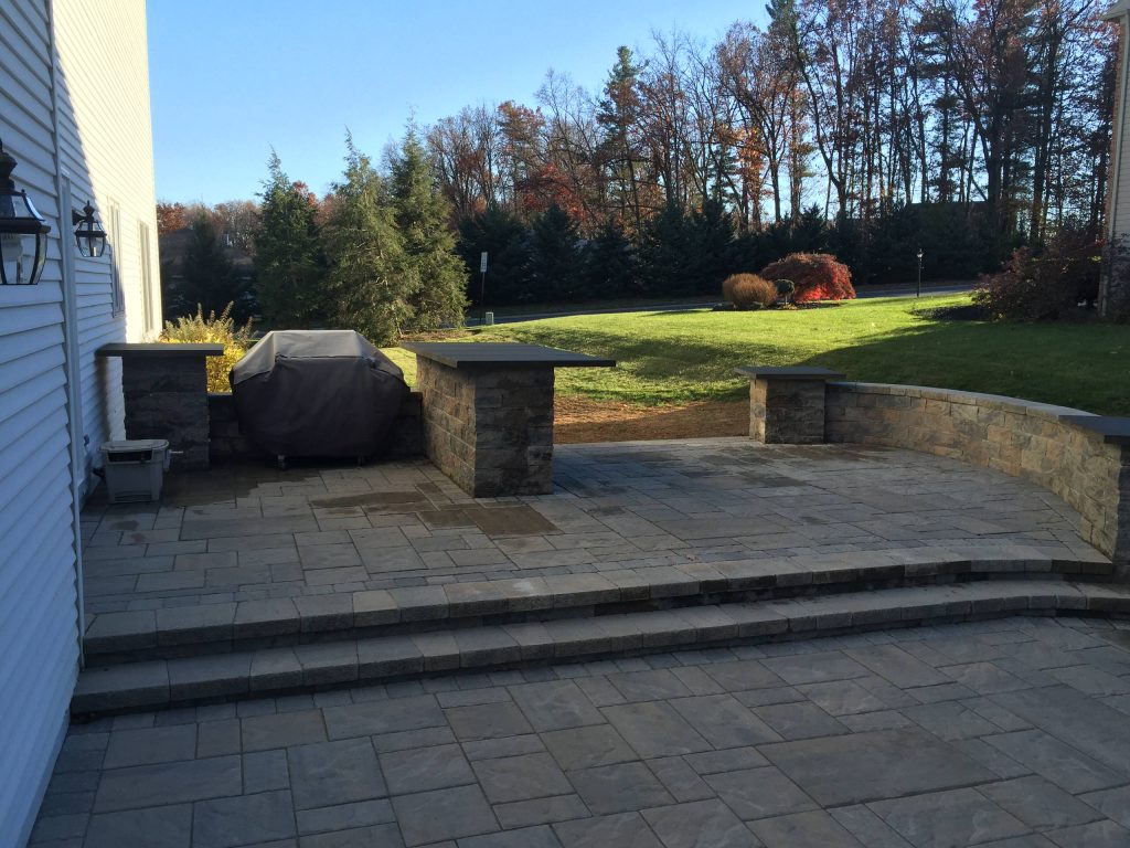 Complete Install of the backyard patio, including the raised kitchen area and steps, custom bar tops and comfortable sitting wall. All completed in Techo-Bloc Blu 60