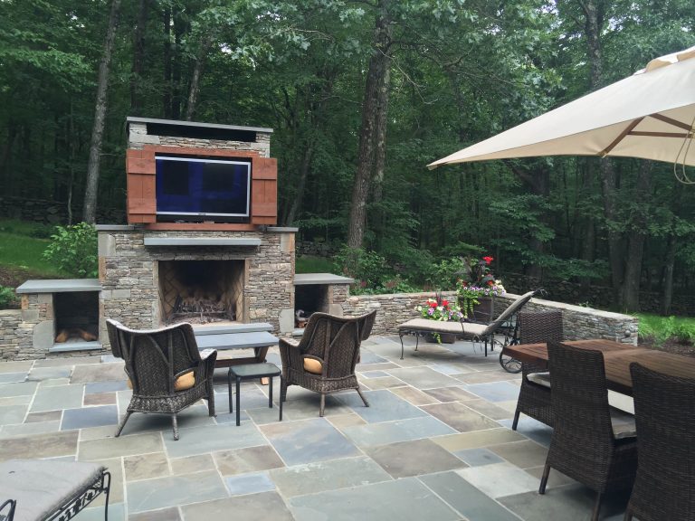 Complete new rear entertainment area including a blue stone terrace, outdoor grilling area, and built in fireplace